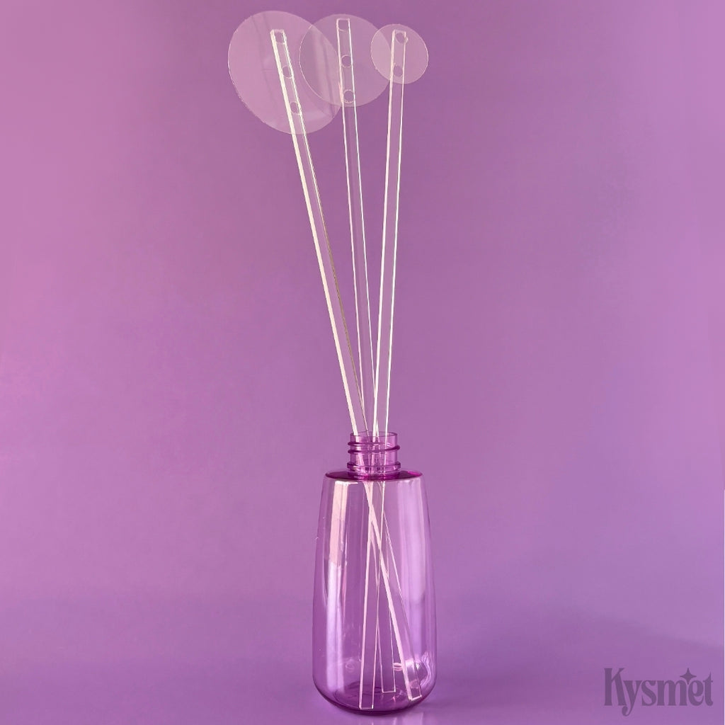 A purple bottle holds three plastic sticks with circular pieces of acetate at the top, against a purple background.