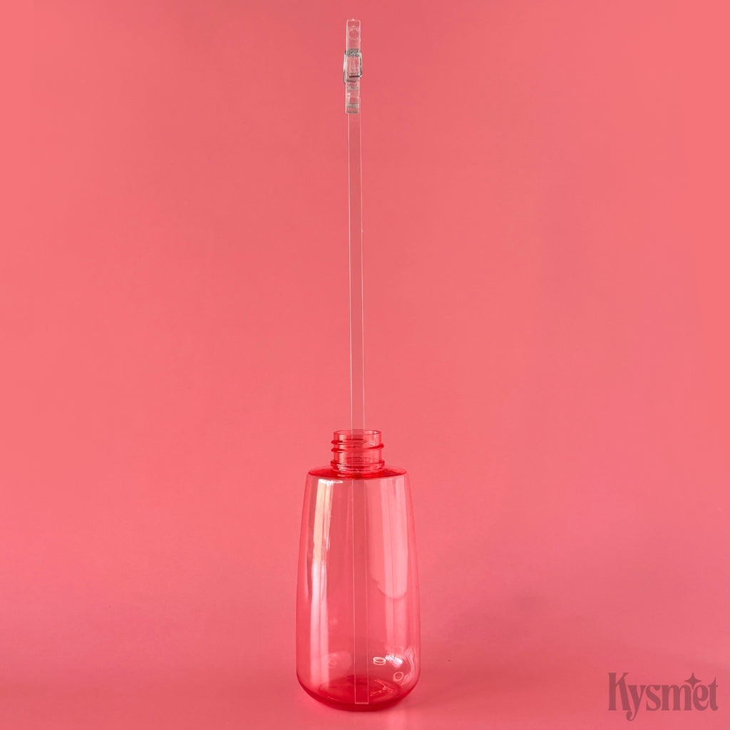 A pink bottle holds a clear plastic stick with a clear clothespin at the top, against a pink background.