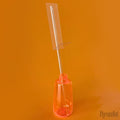 An orange bottle holds a clear plastic stick with a rectangle piece of acetate, against an orange background.