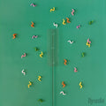 A clear plastic stick with a clear rectangle attached is surrounded by colorful swiggles against a green background.